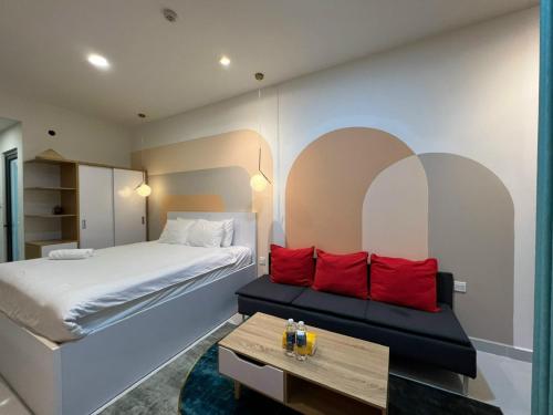 Un dormitorio con una cama con almohadas rojas y una mesa. en Tommy Home in Soho Central Distric 1 SaiGon, en Ho Chi Minh