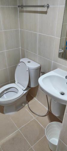 a bathroom with a toilet and a sink at Grand Riviera Suites in Manila