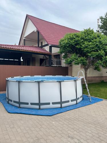 a hot tub sitting on a blue rug in front of a house at Гостевой дом Сафар in Kapchagay