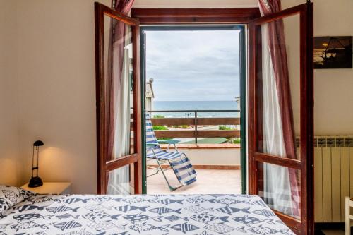 カスティリオーネ・デッラ・ペスカーイアにあるAppartamento vista mare Castiglioneのベッドルーム1室(海の景色を望むバルコニーに面したドア付)