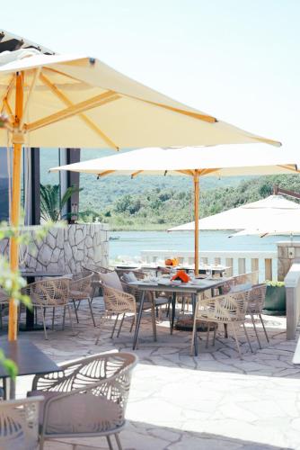 an outdoor patio with tables and chairs and umbrellas at Luxury Sea Residence by Kristina in Tivat