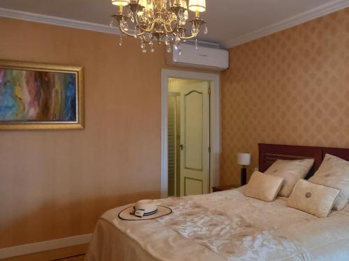 una camera da letto con un letto e un lampadario a braccio di Villa Anna-Altea ad Altea