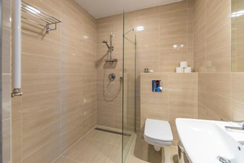 a bathroom with a shower and a toilet and a sink at Spokojne Wczasy in Mielno