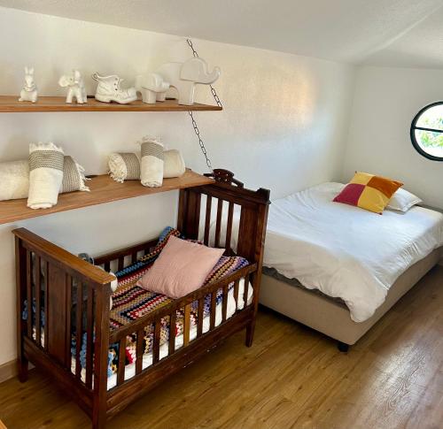 a bedroom with a crib and shelves of towels at Casa Carneirinho by Olá Madeira in Paul do Mar