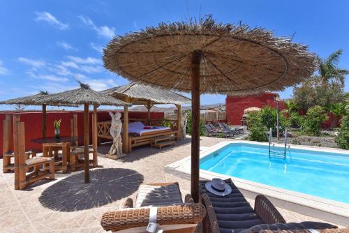 a patio with umbrellas and a swimming pool at Ca'Sita Salobre Pueblo by VillaGranCanaria in San Bartolomé de Tirajana