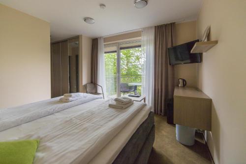 a bedroom with a large bed and a window at Spokojne Wczasy in Mielno