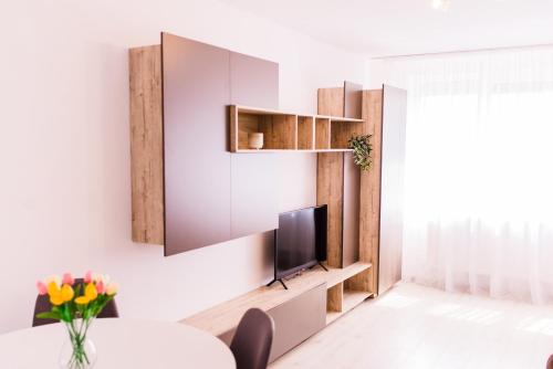 a living room with a tv on a wall at Riverside White Apartment in Satu Mare