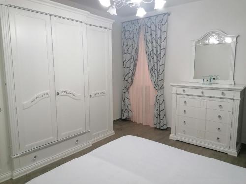 a bedroom with white cabinets and a sink and a mirror at Albachiara in Ruffano