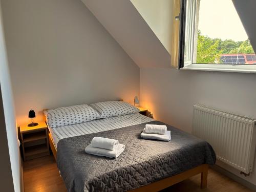 a bedroom with a bed with two towels on it at DW Róża Wiatrów in Dębki