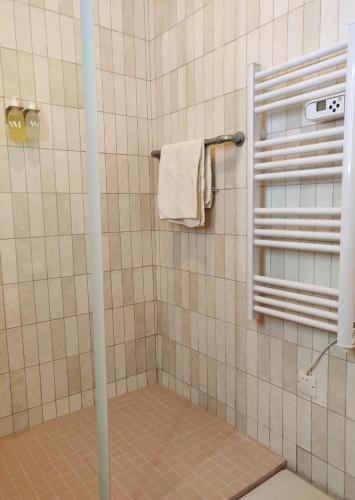 La salle de bains est pourvue d'une douche et d'une serviette. dans l'établissement Maison Mandavi, studio d'hôtes dans l'Entre deux mers, à Loupes