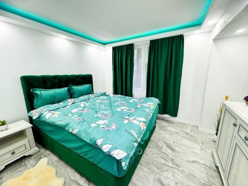 ein Schlafzimmer mit einem Bett mit einer grünen Bettdecke in der Unterkunft Citadel Majestic Apartament in Sighişoara