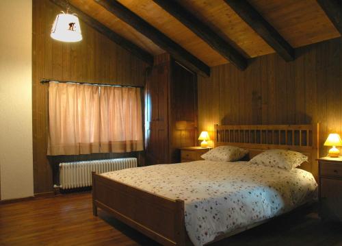 a bedroom with a large bed and two lamps at B&B della Miniera in Cogne