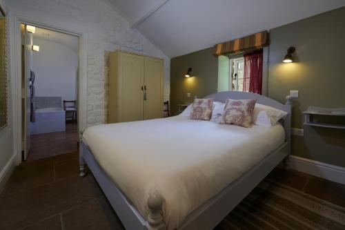 a bedroom with a large bed with white sheets and pillows at The Old Wash HouseChatsworth Estate in Baslow