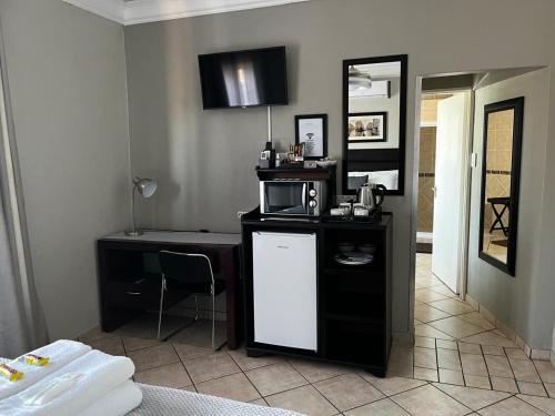 a kitchen with a table and a microwave in a room at Klyne Jiweel Guesthouse in Pretoria