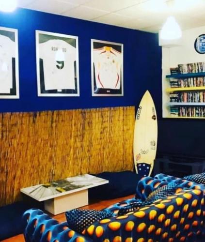 a living room with a surfboard and a couch at The Paintshop Hostel in Figueira da Foz