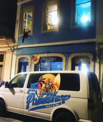 a white van parked in front of a building at The Paintshop Hostel in Figueira da Foz