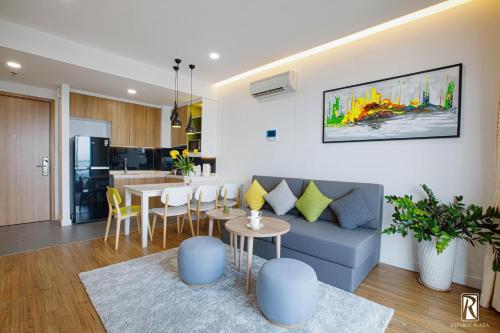 a living room with a blue couch and a kitchen at BIG PROMO - Republic Plaza Cong Hoa Apartment in Ho Chi Minh City