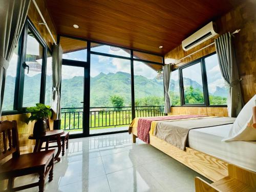 a bedroom with a bed and a view of mountains at Du Gia Field View Homestay in Làng Cac