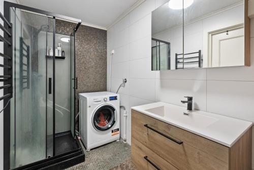 クリスティアンサンにあるPenthouse Apartmentの洗濯機と洗面台を備えたバスルーム