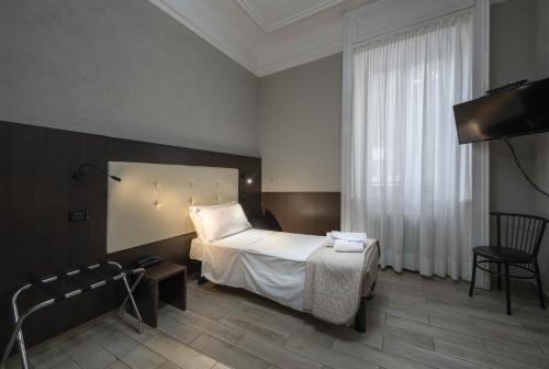 a hotel room with a bed and a television at Hotel Bogart Milano in Milan