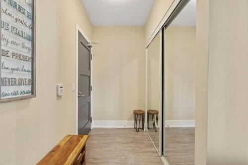a hallway with two stools and a glass door at 3BR Skyline Condo - By CN Tower & MTCC & Free Parking in Toronto