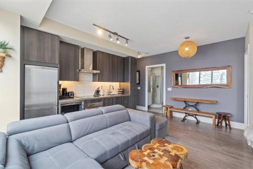 a living room with a blue couch and a kitchen at 3BR Skyline Condo - By CN Tower & MTCC & Free Parking in Toronto