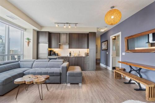 a living room with a couch and a kitchen at 3BR Skyline Condo - By CN Tower & MTCC & Free Parking in Toronto