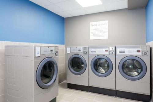 a row of washing machines in a laundry room at Holiday Inn Express & Suites Tampa Stadium - Airport Area by IHG in Tampa