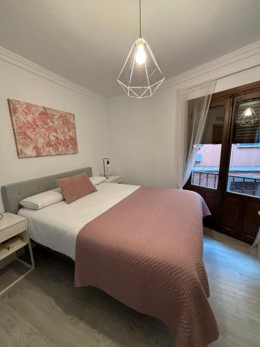 - une chambre avec un grand lit et une lampe pendant dans l'établissement Santa Justa Toledo Centro, à Tolède