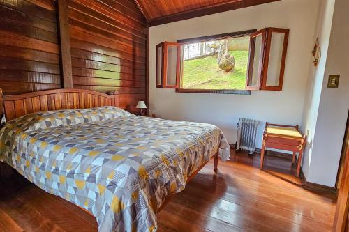 um quarto com uma cama e uma janela em Pousada dos Quatis em Campos de Jordão