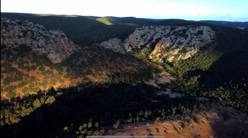 an aerial view of a canyon with trees and mountains at Bens White House in AÃ¯n el Ksob