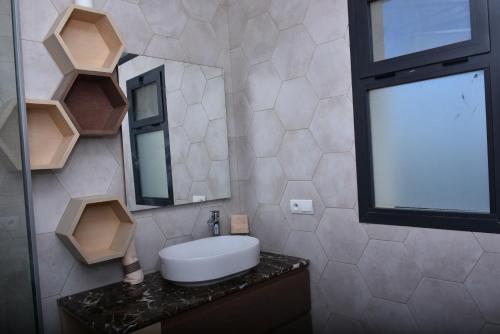 a bathroom with a sink and a mirror at Bens White House in AÃ¯n el Ksob