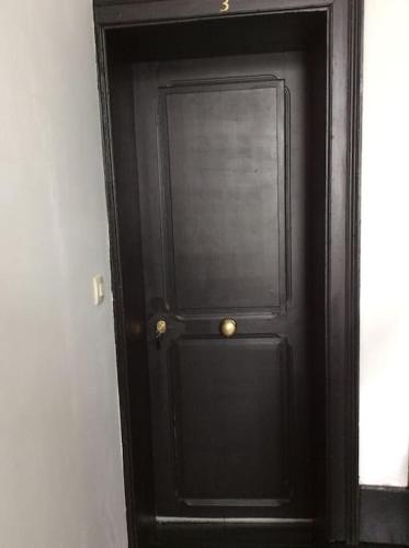 une porte noire avec une poignée de porte dorée dessus dans l'établissement Charmant STUDIO, à Valenciennes