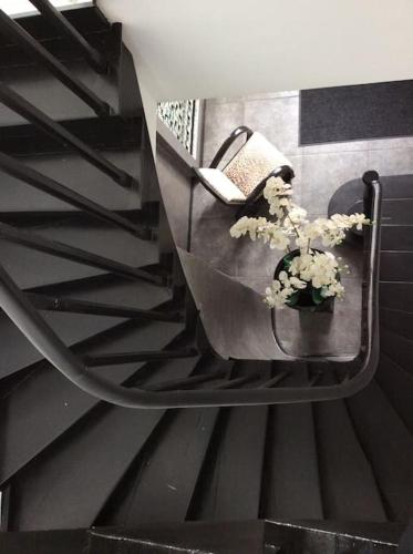 un escalier avec une table avec un panier de fleurs dans l'établissement Charmant STUDIO, à Valenciennes