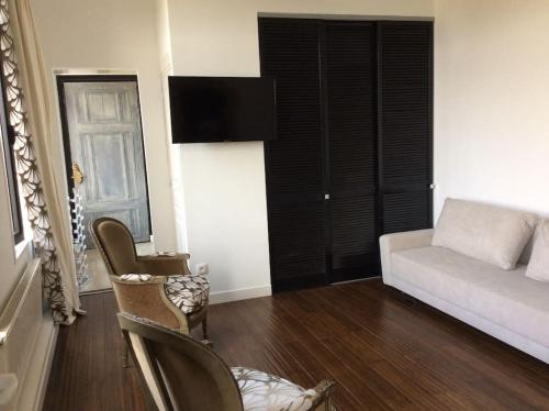 un salon avec un canapé et une chaise dans l'établissement Charmant STUDIO, à Valenciennes