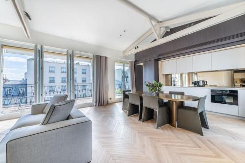 une cuisine et une salle à manger avec une table et des chaises dans l'établissement Luxueux Appartement Haussmannien avec Vue sur Paris, à Paris