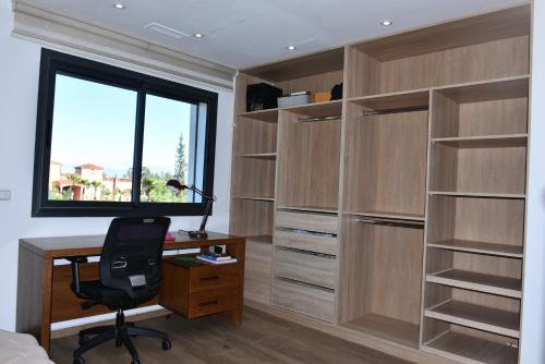 a bedroom with a desk and a window at Bens White House in AÃ¯n el Ksob