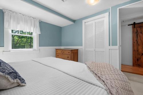 ein Schlafzimmer mit einem weißen Bett und einem Fenster in der Unterkunft 5 Beach Road East Sandwich - Sandy Toes & Salty Kisses in East Sandwich