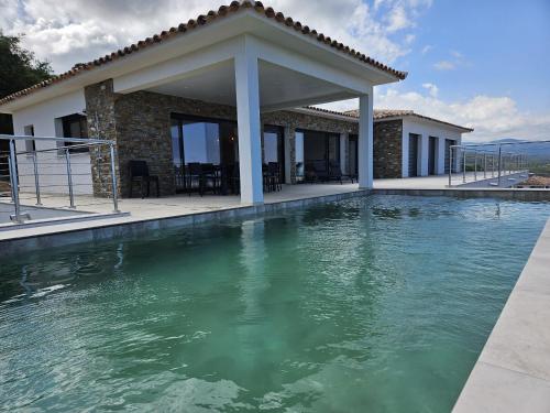 une villa avec piscine devant une maison dans l'établissement LABELLE- Vue mer panoramique - Piscine privée - Clim -WIFI, à Sari-Solenzara
