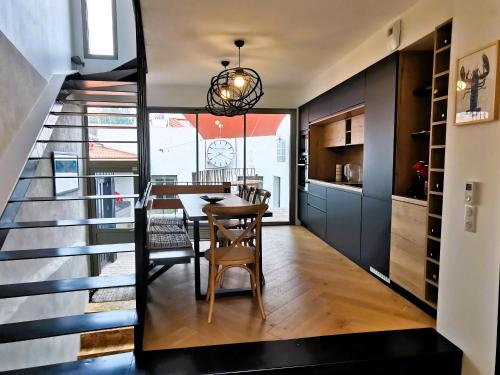 une cuisine et une salle à manger avec une table et un escalier dans l'établissement La Maison de la Sirene, à Les Sables-dʼOlonne