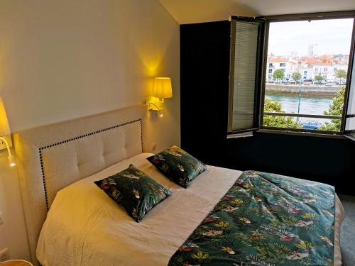 - une chambre avec un lit avec deux oreillers et une fenêtre dans l'établissement La Maison de la Sirene, à Les Sables-dʼOlonne