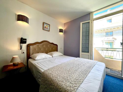 a bedroom with a bed and a large window at Le National Sète Centre Gare,Ascenseur in Sète