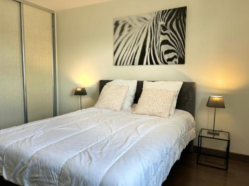 une chambre avec un lit blanc avec une peinture de zèbre sur le mur dans l'établissement 103 - Appartement vue mer pour 4 personnes, à Fréhel