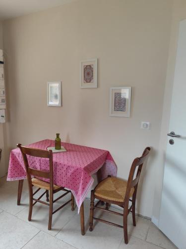 une table avec une nappe rose et deux chaises dans l'établissement Appartement La pierre de bresse, à Pierre