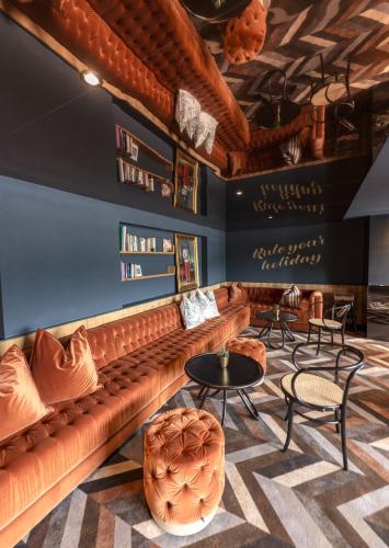 a bar with a leather couch and tables and chairs at Erzherzog Johann Alpin Style Hotel - Adults Only in Schladming