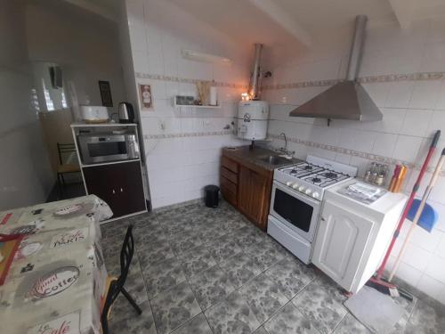 Una cocina con una estufa blanca y un fregadero. en Estrellas del Sur, en Río Gallegos