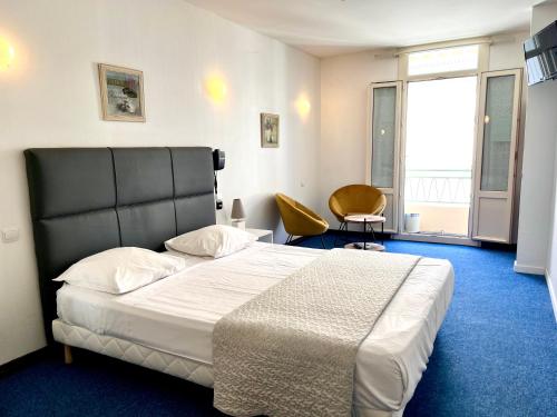 a bedroom with a large bed and a large window at Le National in S&egrave;te