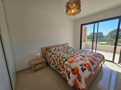 - une chambre avec un lit doté d'un couvre-lit floral et d'une fenêtre dans l'établissement Appartement de standing Lema- clim-wifi- 3 chambres, à Lecci