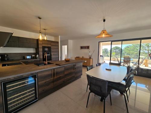 une cuisine et une salle à manger avec une table et des chaises dans l'établissement Appartement de standing Lema- clim-wifi- 3 chambres, à Lecci