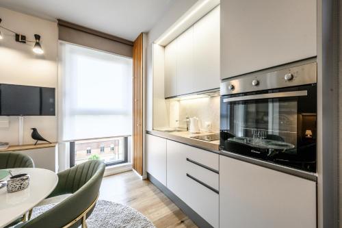 a kitchen with white cabinets and a table with a dining room at Tiny House Tower in Fidenza
